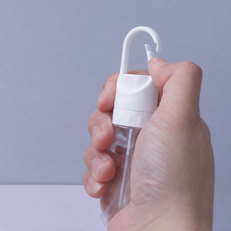hand-operating-clear-clip-on-travel-spray-bottle.jpeg