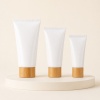 three-white-pe-cosmetic-tubes-with-bamboo-look-caps.jpg