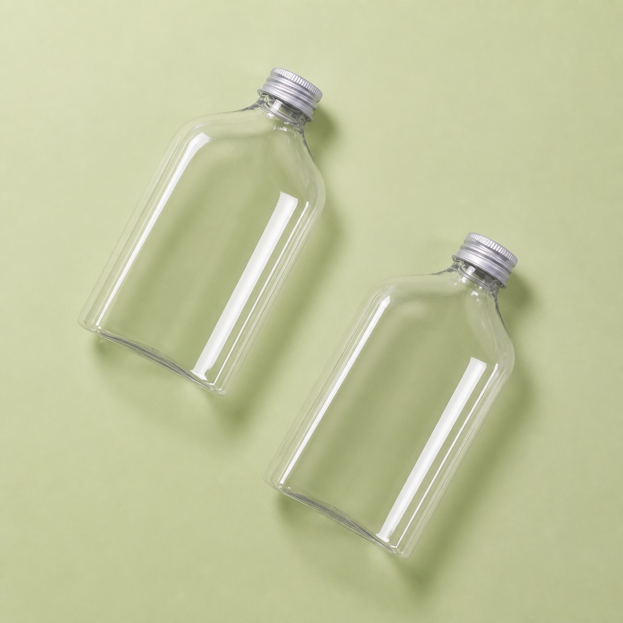 two-flat-pet-beverage-bottles-on-sage-background