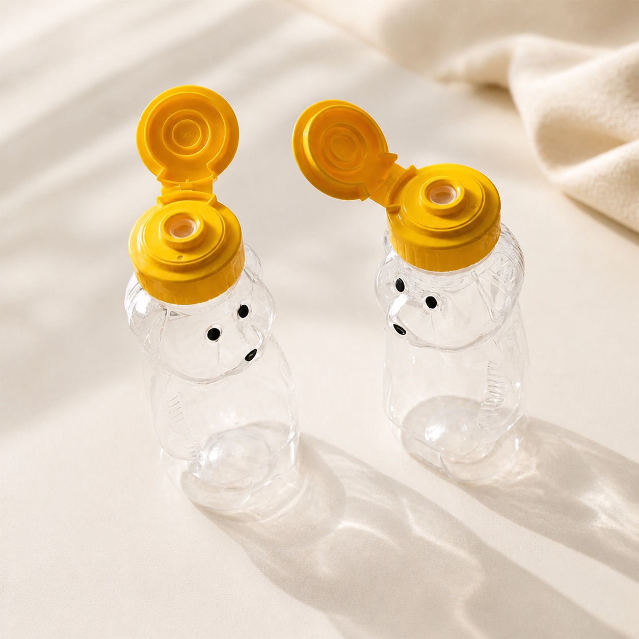 open-yellow-valve-caps-on-clear-bear-bottles